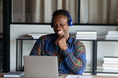 Gülümseyen Afrikalı Amerikalı adam bilgisayardaki video görüşmesinde konuşuyor