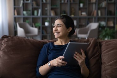 Gülümseyen Hintli kadın tablet kullanarak rüya görüyor.