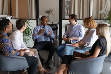 Çok ırklı çalışanlar takım toplantısında fikirleri tartışıyor