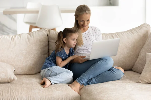 Mutlu anne ve Z 'nin kızı birlikte dizüstü bilgisayar kullanıyor.