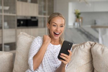 Mutlu heyecanlı akıllı telefon kullanıcısı sevinç çığlıkları atıyor, iyi haberler alıyor