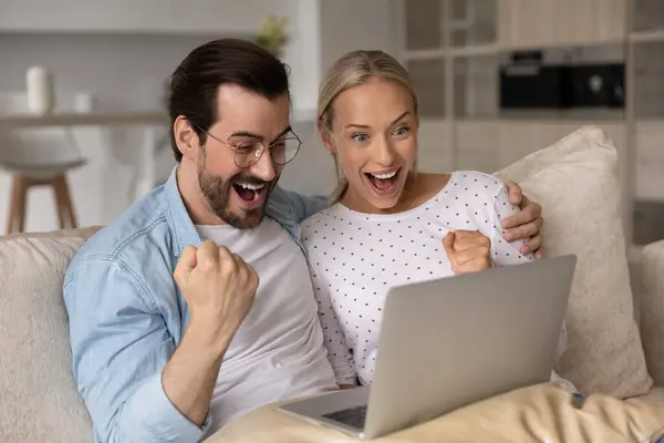Χαρούμενο ενθουσιασμένο ζευγάρι χιλιετιών με ψηφιακή συσκευή που γιορτάζει την επιτυχία — Φωτογραφία Αρχείου