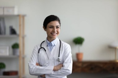 Kendinden emin, mutlu, Hintli bir kadın doktor içeride duruyor..