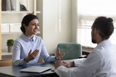 Gülümseyen Hintli hasta Afrikalı doktorla konuşuyor..
