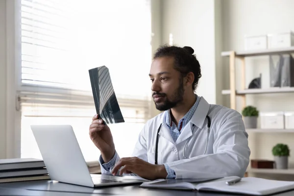 Koncentrerad ung afrikansk amerikansk traumatolog konsultera patienten. — Stockfoto