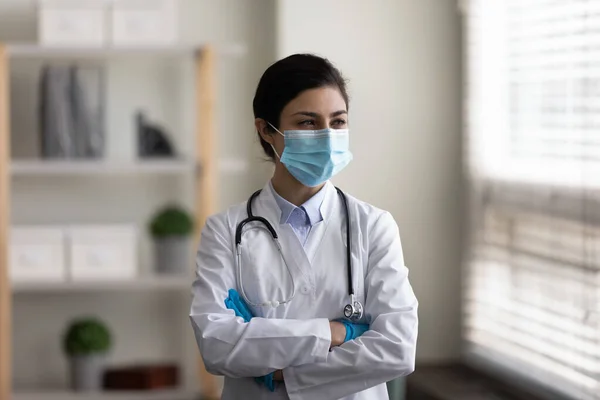 Lost in thoughts young indian doctor standing in clinic. — Stock Photo, Image