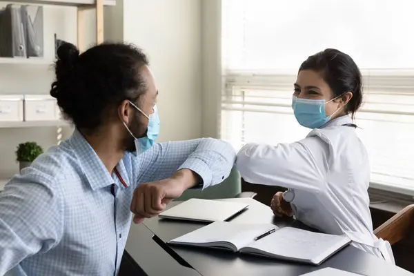 Happy young mixed race patient and doctor touching elbows. — Stock Photo, Image