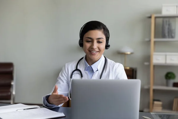 Happy friendly young indian doctor holding video call meeting.