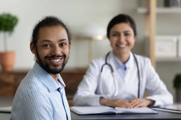 Sonriente paciente afroamericano visitando médico indio. —  Fotos de Stock