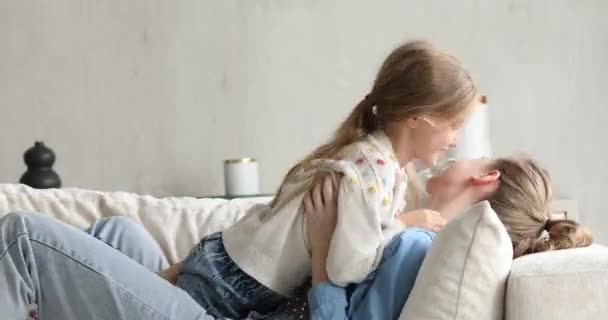 Vrouw haar dochtertje zitten op bank genieten grappig speeltijd — Stockvideo