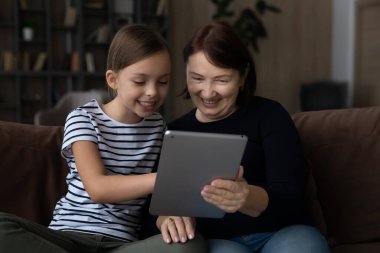 Küçük mutlu kız, büyük annesiyle tablet kullanıyor..