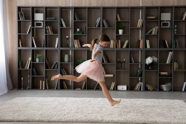 Menina pequena feliz se divertindo na sala de estar moderna. — Fotografia de Stock