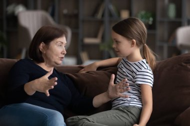 Mutlu yaşlı büyükanne samimi küçük torunla konuşuyor..