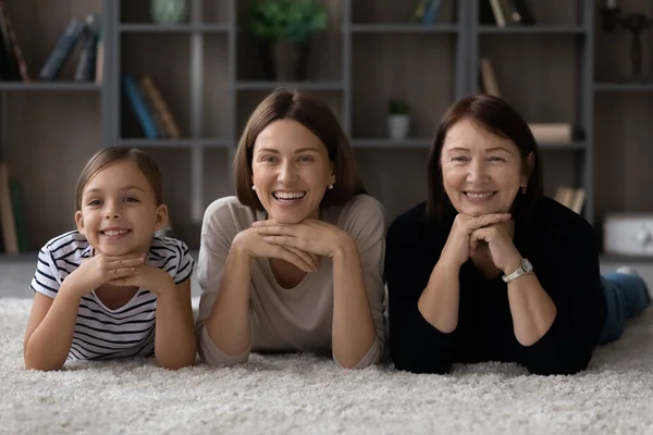 Feliz positivo três gerações femininas família deitada no tapete. — Fotografia de Stock