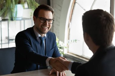 İnsan kaynakları müdürü iş görüşmesinde heyecanlı aday elini sıkıyor