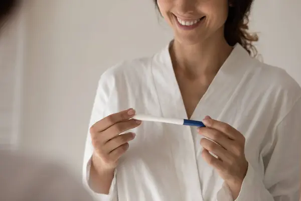 Gestutzte lächelnde junge Frau mit Schnellschwangerschaftstest. — Stockfoto