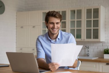 Mutlu genç iş adamı iyi haberlerle gazete okuyor..