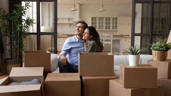 Soñador joven feliz familia pareja descansando en el sofá. — Foto de Stock