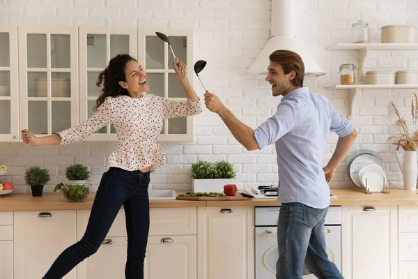 Heureux jeune couple de famille s'amuser dans la cuisine moderne. — Photo