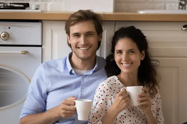 Portrait de jeune couple souriant tenant des tasses de thé. — Photo