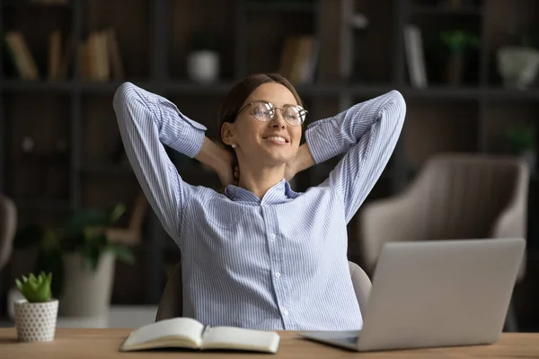 Donna d'affari sorridente in occhiali che si rilassa sul posto di lavoro dopo il lavoro fatto — Foto Stock