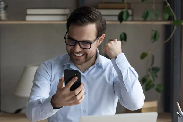 Emocionado usuario de teléfonos móviles disfrutando de ganar, celebrando el éxito — Foto de Stock