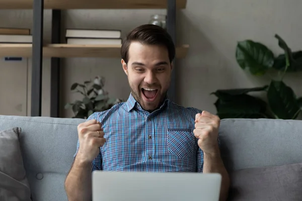 Opgewonden vreugdevolle duizendjarige man staren naar laptop scherm thuis — Stockfoto