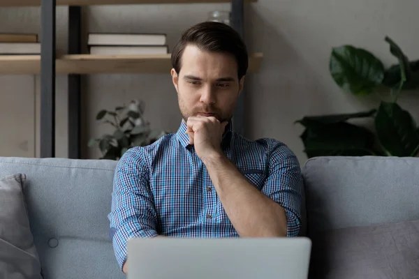 Enfocado joven millennial hombre viendo o leyendo contenido de medios en línea —  Fotos de Stock