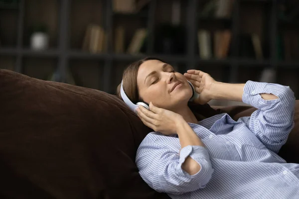 Tutup wanita yang tenang di headphone menikmati musik, santai — Stok Foto