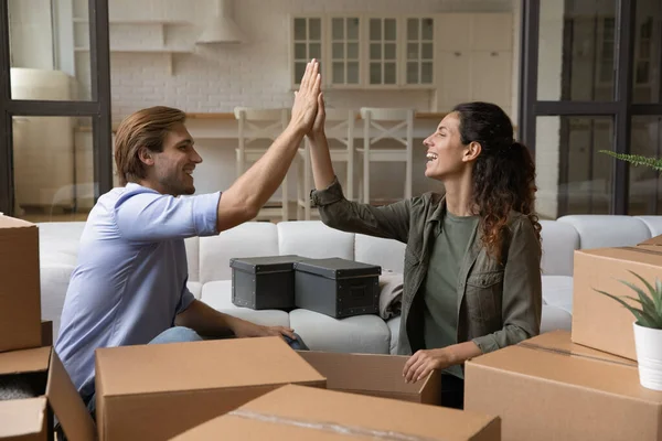 Feliz joven familia pareja desempacar cosas juntos. — Foto de Stock