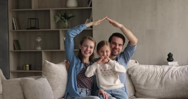 Wellbeing majitelé domů rodina sedět na pohovce pózovat na kameru — Stock video