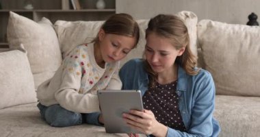 Anne ve kızı dijital tablo kullanarak eğleniyorlar.