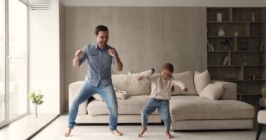 Neşeli adam küçük sevimli kızıyla aktif dansların tadını çıkarıyor.