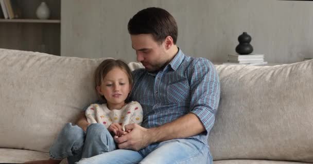 Kärleksfull far omfamna liten flicka under varma pålitliga samtal inomhus — Stockvideo