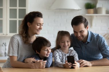 Video görüşmesi için cep telefonu kullanan mutlu ebeveynler ve çocuklar