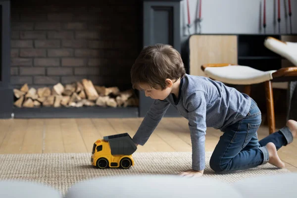 Focado menino brincando com brinquedos no piso de aquecimento em casa — Fotografia de Stock