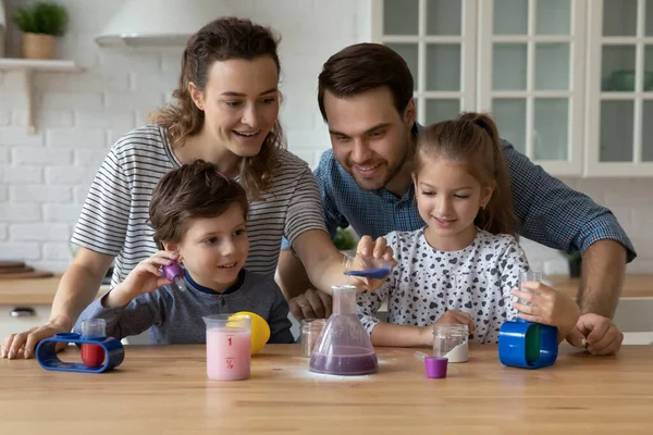 Juegos Pareja feliz y hermanos niños comprometidos en el aprendizaje de química juego — Foto de Stock