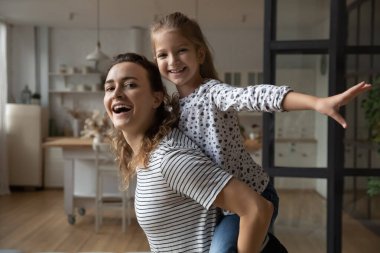 Mutlu güçlü aktif anne sırtımda neşeli kız