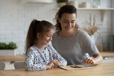 Mutlu nişanlı anne ve kız çocuk masa oyununda eğleniyor.