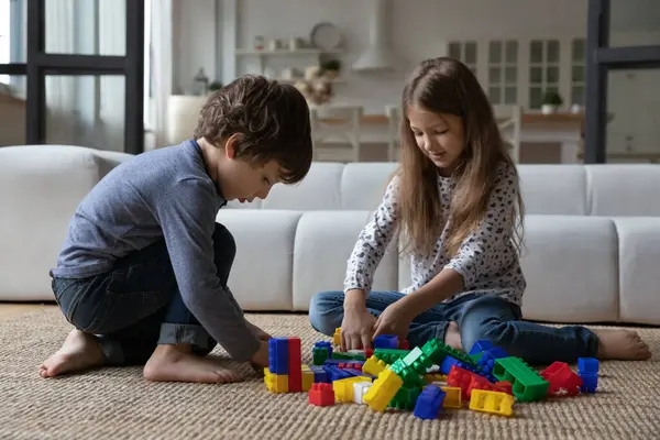 Cute sibling kids constructing toy tower, completing model — Stock Photo, Image