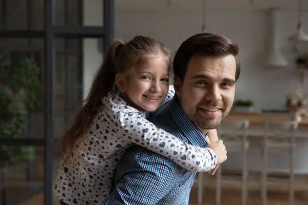 Retrato feliz millennial mejor papá piggybacking hija niño en casa — Foto de Stock