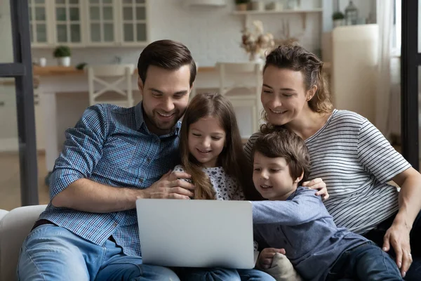 Casal feliz de pais e filhos descansando no sofá — Fotografia de Stock