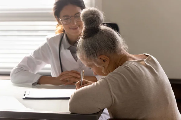 Documento de llenado de anciana en la consulta del médico — Foto de Stock