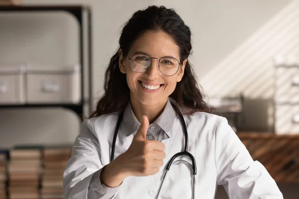 Retrato en la cabeza de la mujer feliz médico de cabecera mostrando como — Foto de Stock