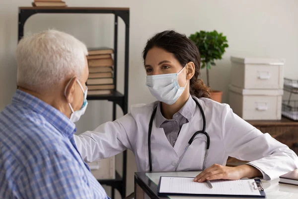 GP doctor in face mask giving support and consultation — Stock Photo, Image