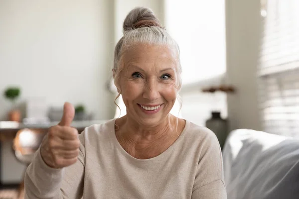 Mutlu, pozitif, yaşlı kadın el hareketi yapıyor, başparmağını kaldırıyor. — Stok fotoğraf