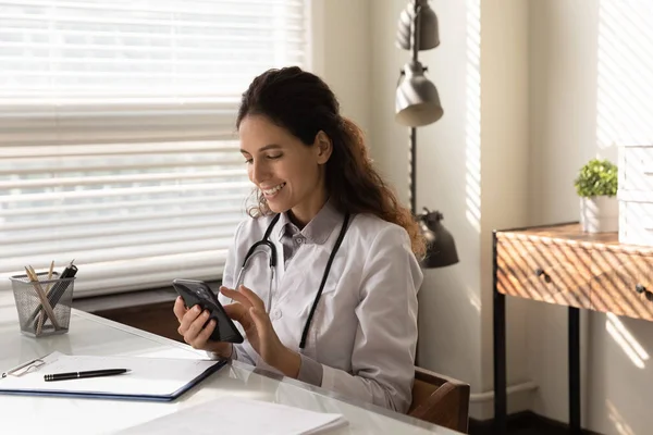 Felice giovane medico generico chatta online sul cellulare — Foto Stock