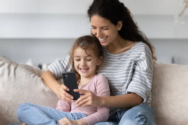 Madre feliz e hija pequeña usando aplicaciones de teléfonos celulares. — Foto de Stock