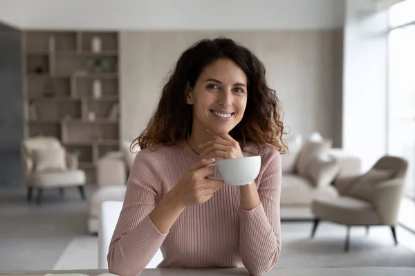 Souriant jeune femme hispanique attrayante boire du café. — Photo