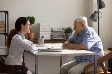 Gülümseyen genç doktor ve olgun 80 'lerin hasta toplantısı